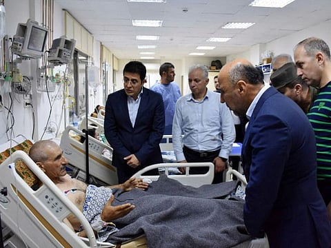 Syria's Health Minister Hassan Mohammad Al Ghobash visiting the injured in the aftermath of a drone attack targeting a Syrian military academy in Homs.  