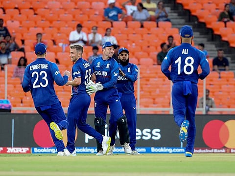 England's skipper Jos Buttler and Sam Curran celebrate the wicket of New Zealand's Will Young during the opening match of the ICC Cricket World Cup 2023, at Narendra Modi Stadium, in Ahmedabad on Thursday. 