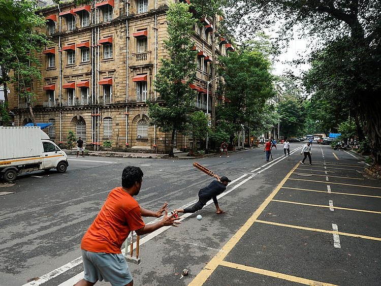 People play cricket on an empty street in Mumbai
