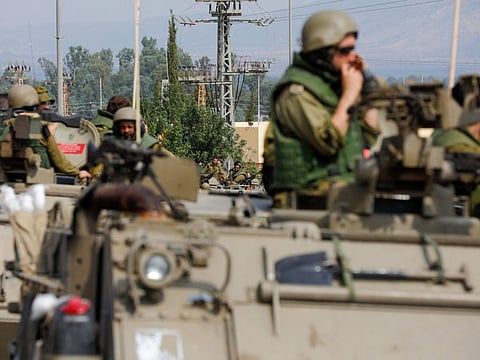 Israeli soldiers in an armoured vehicles drive along a street near northern town of Kiryat Shmona close to the border with Lebanon on October 9, 2023.  