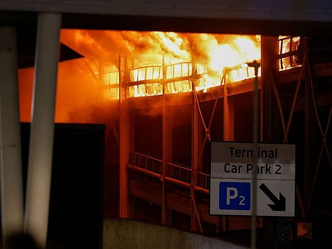 Flames are seen as emergency services respond to a fire in Terminal Car Park 2 at London Luton airport.