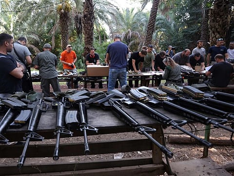 Israelis arrive at a weapons distribution point for people allowed to carry arms, at the Ayyelet HaShahar Kibbutz, in northern Israel, near the Lebanese border on October 12, 2023.  