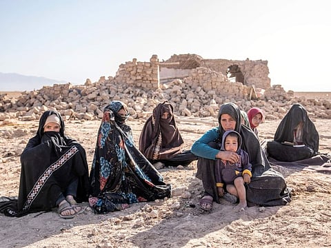 Afghan women sit in front of their houses that were destroyed by the earthquake in Zenda Jan district in Herat province.