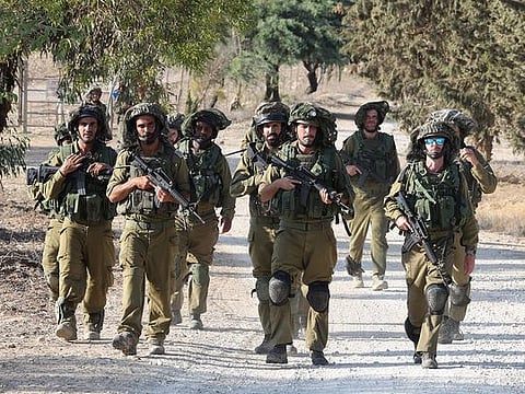 Israeli troops patrol at an undisclosed location along the border with the Gaza Strip on October 19, 2023.  