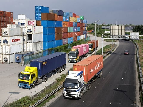 Lorries drive past containers stacked near the Northport in Port Klang, Selangor, Malaysia, on Wednesday, Oct. 11, 2023. Malaysia is expected to release trade figures on Oct. 19. Photographer: Samsul Said/Bloomberg