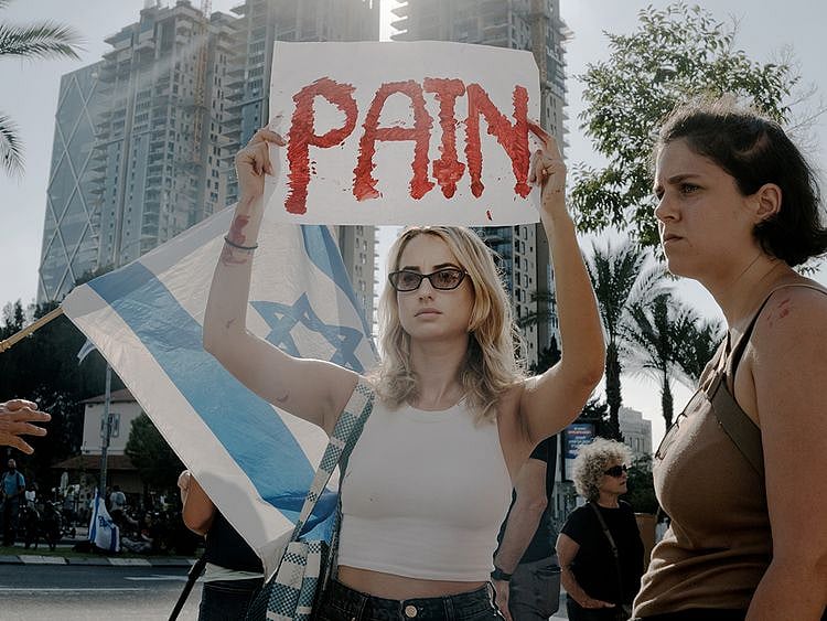 An woman holds a sign that reads "Pain" during a protest for the release of hostages in Tel Aviv, Israel. 