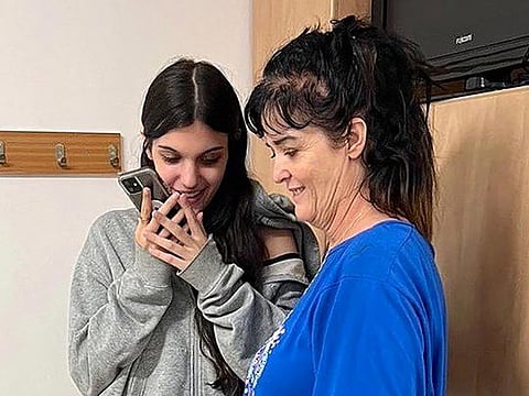 This handout picture courtesy of the United States embassy in Jerusalem taken on October 20, 2023 shows Natalie Shoshana Raanan (L) and Judith Tai Raanan speaking on the phone with US President Joe Biden, after being held hostage and later released by Hamas. 