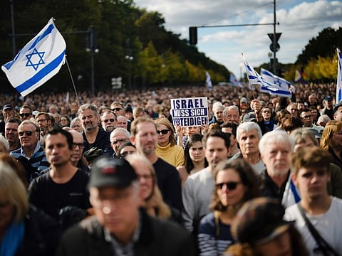 A woman shows a poster reading: "Israel must defend itself" a demonstration against anti-semitism and to show solidarity with Israel in Berlin, on Sunday. 