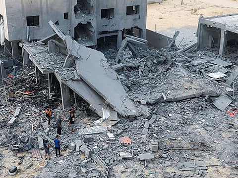 Palestinians inspect the site of Israeli strikes on a house in Khan Younis in the southern Gaza Strip