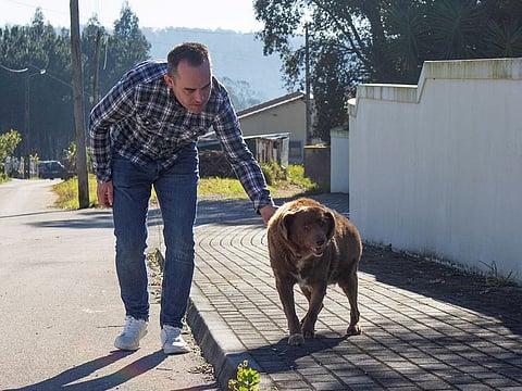 Leonel Costa walks the dog, Bobi, that broke the record for oldest dog ever at 30 years-old, at Conqueiros, in Leiria, Portugal, February 4, 2023.