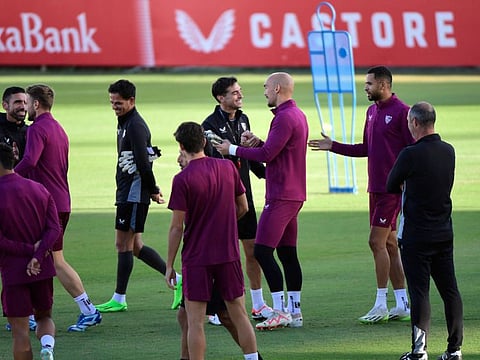 Sevilla's Uruguayan coach Diego Alonso (centre) welcomes Sevilla's Serbian goalkeeper Marko Dmitrovic and the rest of teammates as they arrive for a training session at the Jose Ramon Cisneros Palacios sports city in Seville on Monday.