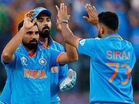 India’s Mohammed Shami celebrates with Mohammad Siraj and KL Rahul after taking the wicket of New Zealand’s Rachin Ravindra in the ICC Cricket World Cup 2023 match at the Himachal Pradesh Cricket Association Stadium, Dharamsala, India, on October 22, 2023. Shami claimed a five-wicket haul that prevented a late assault by Kiwi batters. 
