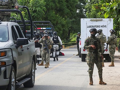 Mexican armed forces stand guard near a crime scene where several local police officers were shot dead by gunmen, in Coyuca de Benitez, Mexico.