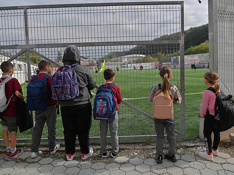 Children watch FC Ballkani's players in training session in Theranda.