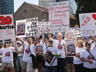 Protesters hold placards and portraits of Israeli hostages, Alon Shamriz and Doron Steinbrecher, held by Palestinian militants since the October 7 attack, during a demonstration calling for their release in Tel Aviv on October 26, 2023.  