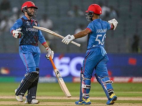 Afghanistan's Azmatullah Omarzai (left) celebrates with his captain Hashmatullah Shahidi after scoring a half-century during the World Cup match against Sri Lanka at the Maharashtra Cricket Association Stadium in Pune on Monday.