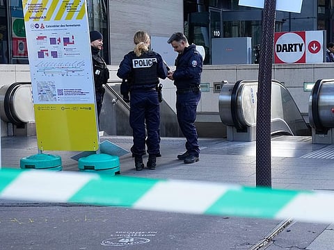 Police officers stand by a subway station after a woman allegedly made threatening remarks on a train, Tuesday, Oct. 31, 2023 in Paris. 