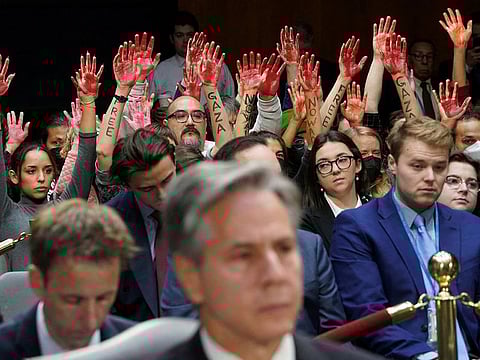 Anti-war protesters raise their "bloody" hands behind US Secretary of State Antony Blinken during a Senate Appropriations Committee hearing on President Biden's $106 billion national security supplemental funding request to support Israel and Ukraine, as well as bolster border security, on Capitol Hill in Washington, on October 31, 2023. 