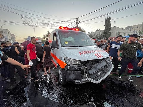 Palestinians check the damages after a convoy of ambulances was hit, at the entrance of Shifa hospital in Gaza City, on November 3, 2023. 