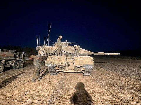 Personnel of the Israel Defence Forces (IDF), stand atop a tank during ground operations at a location given as Gaza, as the conflict between Israel and the Palestinian Islamist group Hamas continues.