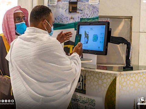 Worshippers make use of digital services at the Grand Mosque. 