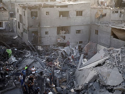 Palestinians search for casualties, at the site of Israeli strikes on houses, amid the ongoing conflict between Israel and Palestinian Islamist group Hamas, at the Magazi Refugee Camp, in central Gaza Strip, November 5, 2023.  Israel’s military campaign in Gaza since October 7 has killed 9,488 people, most of them women and children, the Hamas-run health ministry says.