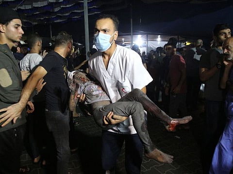 A medic transports a wounded child to Al Shifa hospital in Gaza City late on November 5, 2023.