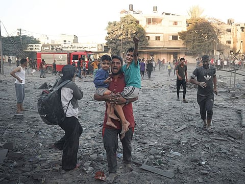 Palestinians walk away after Israeli airstrike in Rafah, Gaza Strip, on November 7, 2023. 