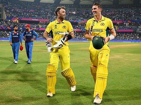 Australia’s Glenn Maxwell (left) and captain Pat Cummins return to the pavilion after steering their team to victory against Afghanistan in the ICC Cricket World Cup at the Wankhede Stadium in Mumbai, India, on November 7, 2023. The win helped Australia enter the semifinals. 