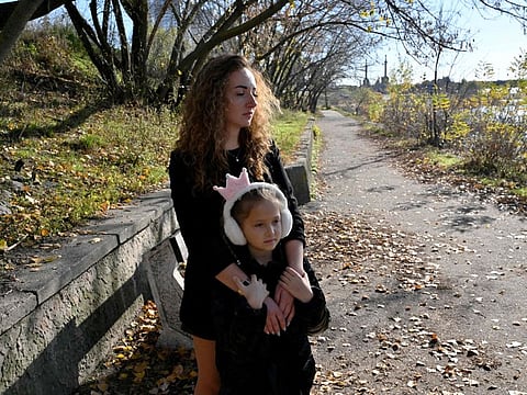 Anna Lyashko, 28, and her daughter Diana, 8, walk in a park near Dnipro river in Kyiv amid the Russian attacks on Ukraine.  