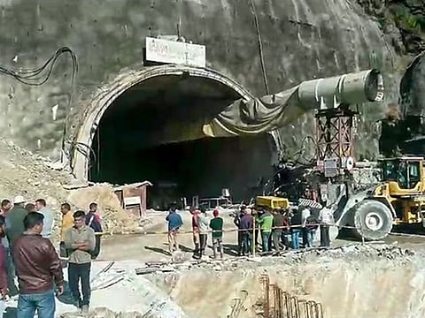 People gather near an under-construction tunnel that connects Silkyara to Dandalgaon after its part collapsed, in Uttarkashi.