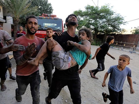 Palestinians carry a wounded girl after being rescued from under the rubble of buildings that were destroyed by Israeli airstrikes in Jabaliya refugee camp, northern Gaza Strip.