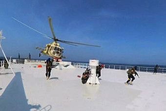 A grab from handout footage released by Al Houthi Ansarullah Media Centre on November 19, 2023, reportedly shows members of the rebel group during the capture of an Israel-linked cargo vessel at an undefined location in the Red Sea.  