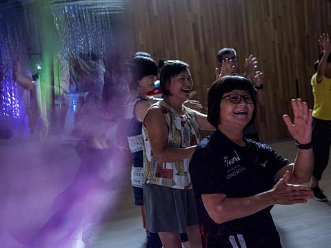 This picture taken on July 31, 2023 shows people taking part in an afternoon disco at a community hall in Hong Kong.