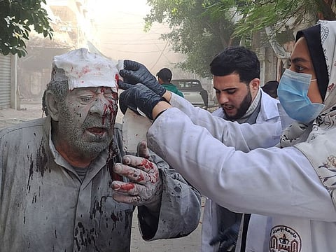 A Palestinian man receives first-aid after an Israeli strike near the Kamal Adwan hospital in Beit Lahia in the northern Gaza Strip on November 22, 2023.  