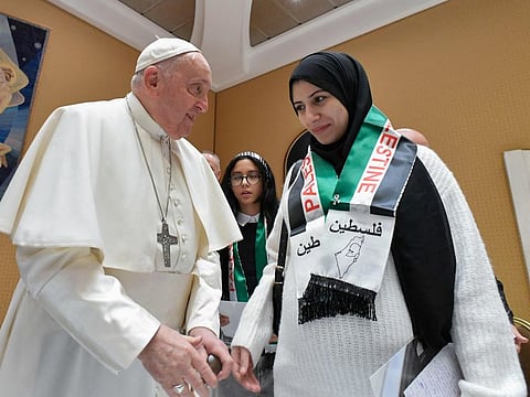Pope Francis speaks with a family member of Palestinians who are currently living through the war in Gaza at the Vatican on November 22, 2023.  