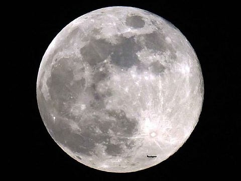 A passenger aircraft flies before the rising beaver moon. The 'beaver' moon moniker, passed down from Native American lore, corresponds to the time of the year when beavers are more active.