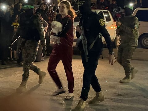 Mia Leimberg with her pet dog Bella and Hamas militants on way to meet the Red Cross officials after her release.  