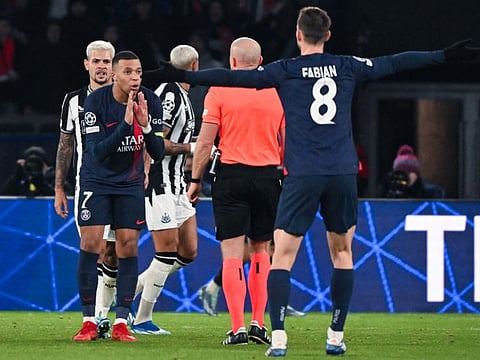 Paris Saint-Germain's forward Kylian Mbappe (left) argues with Polish referee Szymon Marciniak during the Champions League Group F match against Newcastle United on Tuesday.