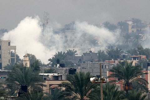 Smoke rises above buildings in Khan Younis in the southern Gaza Strip, as battles between Israel and Hamas militants continue on December 5, 2023.  