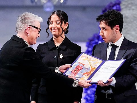 Leader of the Nobel Committee Berit Reiss-Andersen hands over the award to Kiana Rahmani and Ali Rahmani on behalf of their mother during the 2023 Nobel Peace Prize ceremony at the Oslo City Hall on December 10, 2023.  