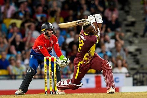Andre Russell of West Indies powers one over the fence as Jos Buttler of England watches during the 1st T20I at Kensington Oval, Bridgetown, Barbados, on Tuesday.