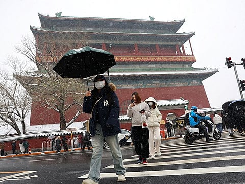  People walk across a road near the Drum Tower in Beijing, China.