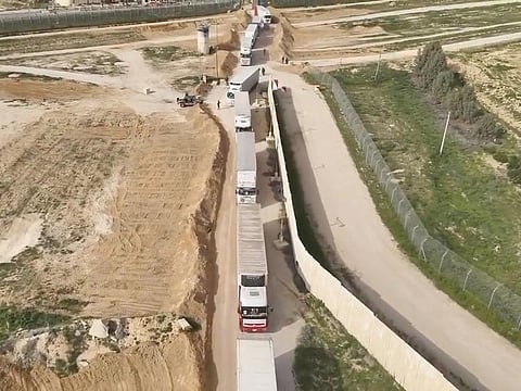 Humanitarian aid trucks wait in line to be inspected at the Kerem Shalom crossing, on the border between Israel, Gaza and Egypt on December 12, 2023.    