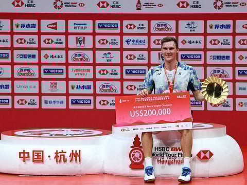 Denmarks Viktor Axelsen poses with the trophy after his win against Chinas Shi Yuqi at the mens singles final match during the BWF Badminton World Tour Finals award ceremony in Hangzhou on Sunday.