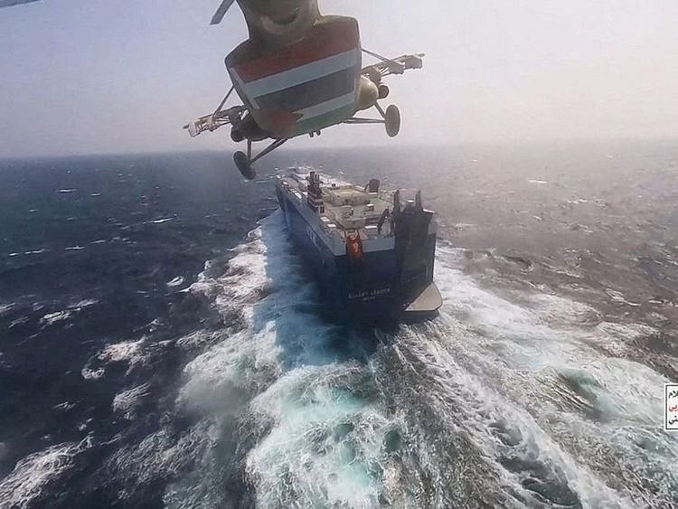 Al Houthi military helicopter flies over the Galaxy Leader cargo ship in the Red Sea in this photo released November 20, 2023.