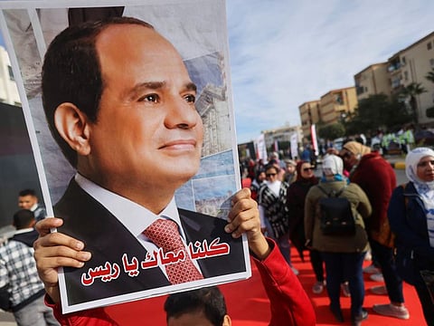 A person carries a picture of Al Sissi on the first day of the presidential election in Cairo on December 10, 2023.  