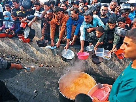 Photos: Hundreds queue up for food in central Gaza 