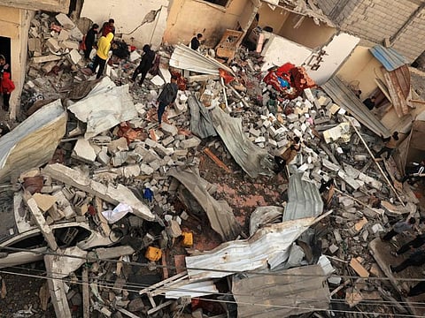 Palestinians inspect a destroyed house after Israeli airstrikes in Rafah, in the southern Gaza Strip on December 20, 2023, amid continuing battles between Israel and the Palestinian militant group Hamas.  
