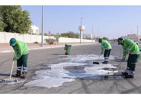 The trio washing a road as part of the community service ordered by the court.